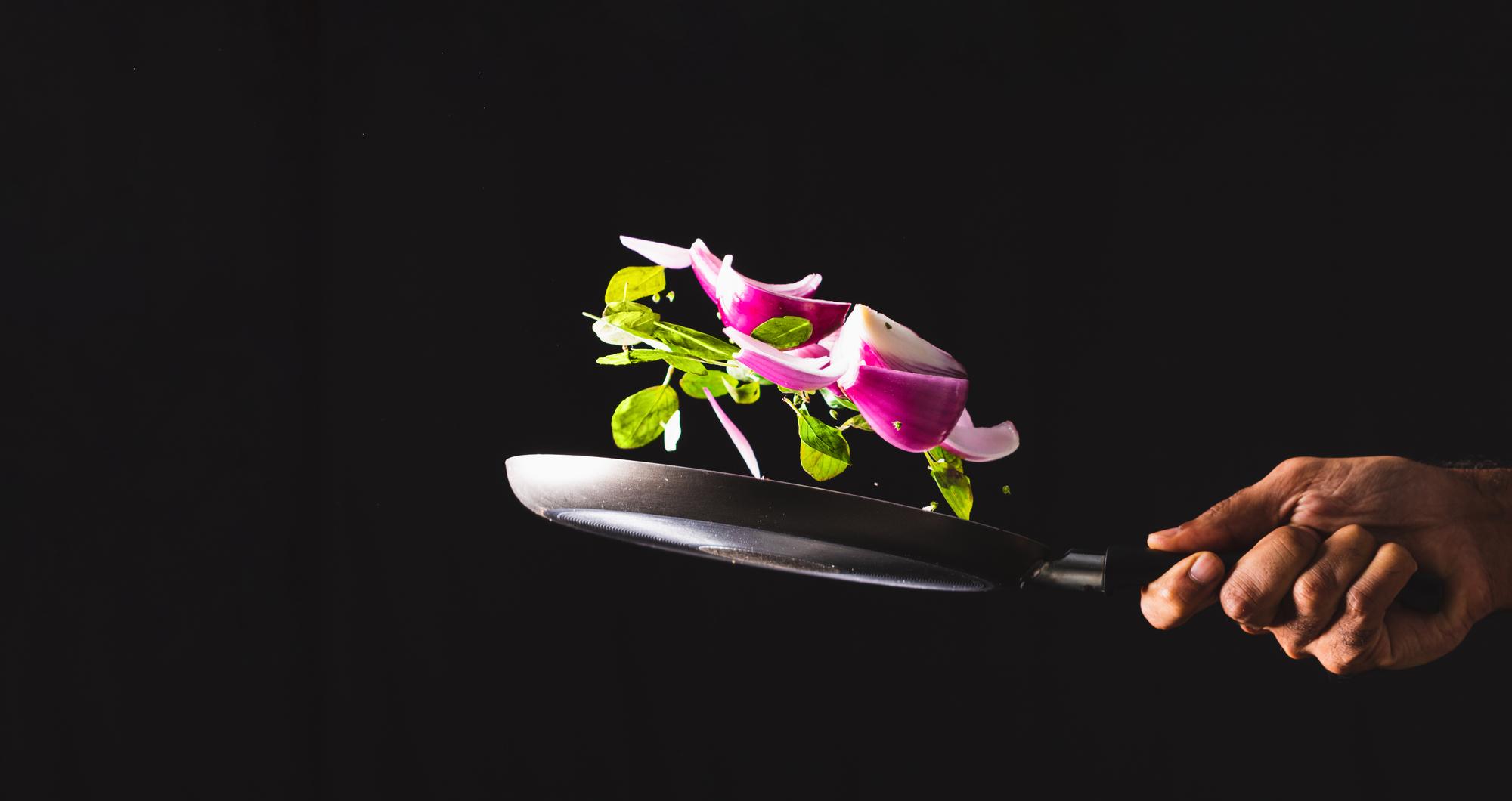 Chef preparing modern plated dish in neon kitchen